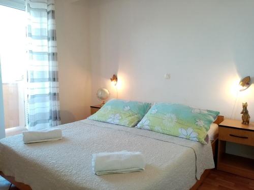 a bedroom with a bed with two towels on it at Apartments by the sea Supetarska Draga - Donja, Rab - 17201 in Rab