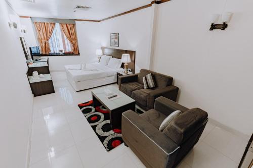 een woonkamer met een bank en een bed bij Panorama Hotel Deira in Dubai