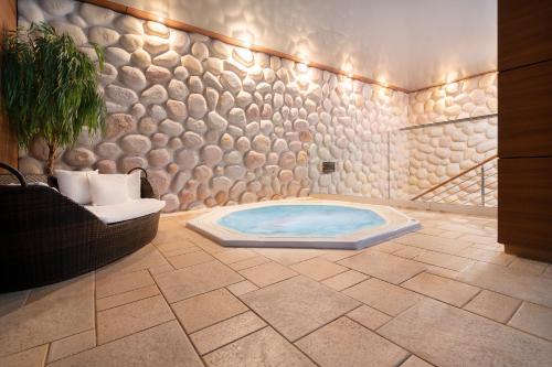 un bagno con vasca idromassaggio in una stanza di Odyssey ClubHotel Wellness&SPA a Kielce