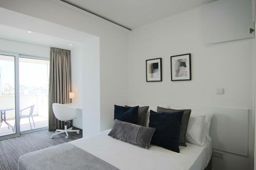 a white bedroom with a bed and a balcony at Phaedrus Living: Luxury Suite Nicosia 506 in Nicosia