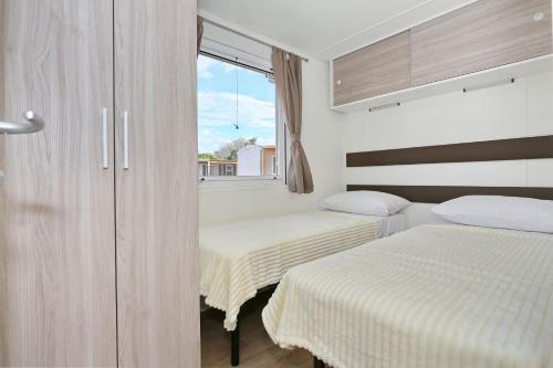 a bedroom with two beds and a window at Apartments by the sea Pasman - 17406 in Pašman
