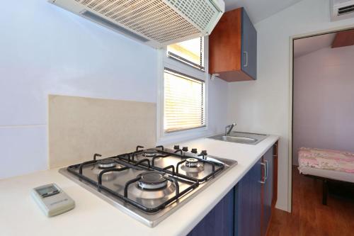 a stove top in a kitchen with a sink at Apartments by the sea Pasman - 17406 in Pašman