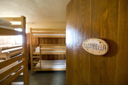 een bord op een houten muur in een kamer met stapelbedden bij Rifugio Chierego - 1911m in Brenzone sul Garda