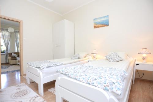 um quarto branco com 2 camas e um sofá em Apartments for families with children Slunj, Plitvice - 17416 em Slunj