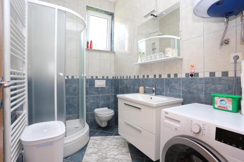 W łazience znajduje się umywalka i pralka. w obiekcie Apartments for families with children Slunj, Plitvice - 17416 w mieście Slunj