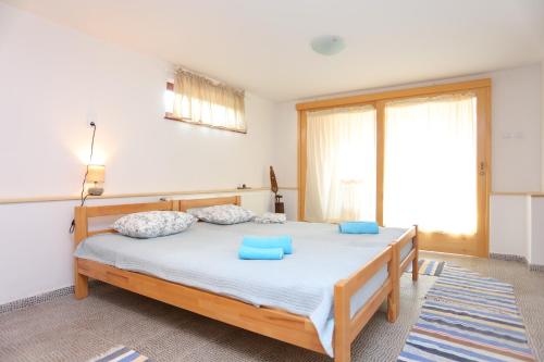 ein Schlafzimmer mit einem großen Bett mit blauen Kissen in der Unterkunft Apartments for families with children Donje Taboriste, Plitvice - 17500 in Slunj