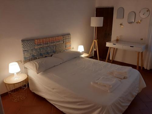 una camera da letto con un grande letto bianco con due asciugamani di La Casina della Volpe a Prato