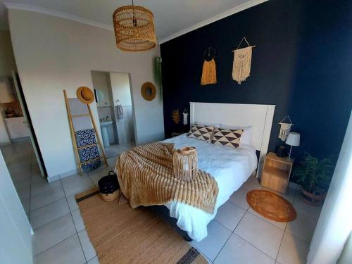 a bedroom with a large bed and a blue wall at Flower Route House in Langebaan