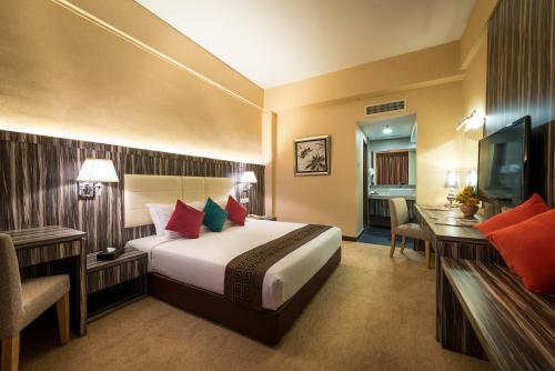 a hotel room with a bed and a desk and a television at Hotel Sentral Melaka @ City Centre in Melaka