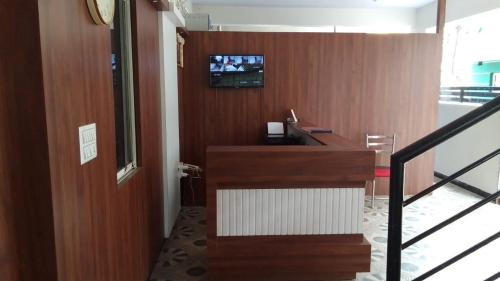 HOTEL NEW SHELTON SUITES في بانغالور: غرفة بها تلفزيون على الحائط ودرج