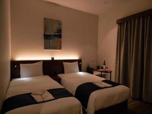 a hotel room with two beds and a window at THE GRAND HOTEL GINOWAN in Ginowan
