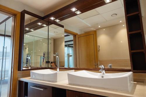 baño con 2 lavabos y espejo grande en Dulive, en Dubái