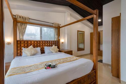- une chambre avec un grand lit et un cadre en bois dans l'établissement Shree Villa 4Bhk Mahabaleshwar, à Mahabaleshwar