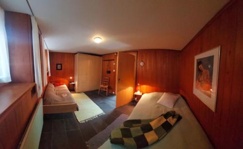 Ferienwohnung-Brienz في برينز: غرفة صغيرة بسريرين في غرفة
