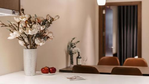 a vase of flowers sitting on a table at DHTS Business Hotel & Apartment in Ho Chi Minh City