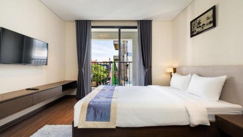 ein Schlafzimmer mit einem großen Bett und einem TV in der Unterkunft DHTS Business Hotel & Apartment in Ho-Chi-Minh-Stadt