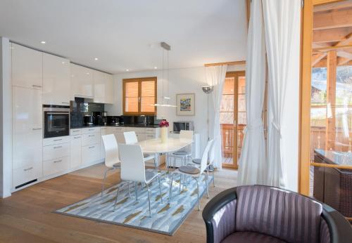 a kitchen and dining room with a table and chairs at Panoramapark Soleil Chalet B in Wengen
