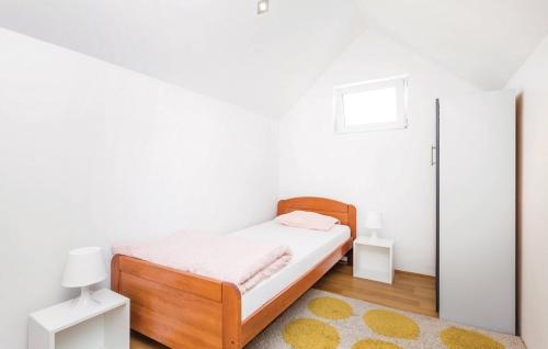 ein weißes Schlafzimmer mit einem Bett und einem Teppich in der Unterkunft Apartments for families with children Jasenak, Karlovac - 17501 in Jasenak