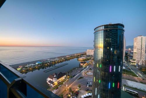 a rendering of a tall building next to the ocean at Come a Lot Aparthotel Batumi in Batumi