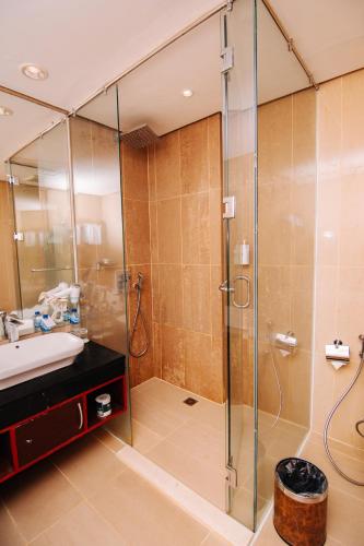 a bathroom with a shower and a sink at Swiss-Belinn SKA Pekanbaru in Pekanbaru
