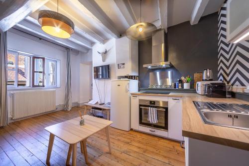 une grande cuisine avec une table et un comptoir dans l'établissement Bel appartement, 2 chambres, Annecy Coeur de ville, à Annecy