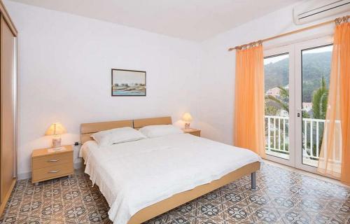 a bedroom with a bed and a large window at Apartments by the sea Povlja, Brac - 17472 in Povlja