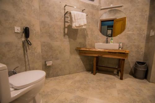 ein Badezimmer mit einem WC, einem Waschbecken und einem Spiegel in der Unterkunft Tibet Hotel in Skardu