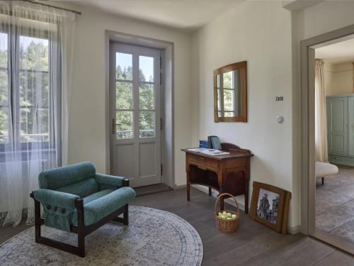 a living room with a chair and a desk and a mirror at Tauhaus in Manětín