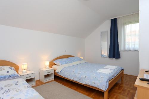 um quarto com 2 camas, uma janela e 2 candeeiros em Apartments with a parking space Donje Taboriste, Plitvice - 17527 em Slunj