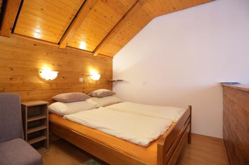 two beds in a room with wooden walls at Apartments and rooms with a swimming pool Grabovac, Plitvice - 17531 in Rakovica