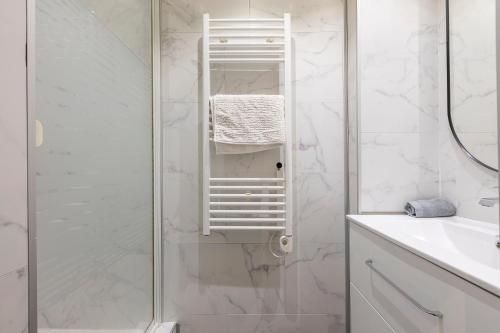 uma casa de banho branca com um chuveiro e um lavatório. em Apt 2-4 pers, charme de l'ancien, calme, vélos, Annecy centre em Annecy