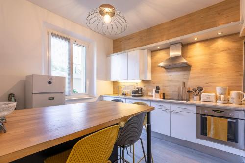 une cuisine avec des armoires blanches et un comptoir en bois dans l'établissement Apt 2-4 pers, charme de l'ancien, calme, vélos, Annecy centre, à Annecy