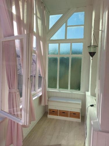 Cette chambre dispose d'une fenêtre avec des rideaux roses et un banc. dans l'établissement Reif&Buffi, à Lahnstein
