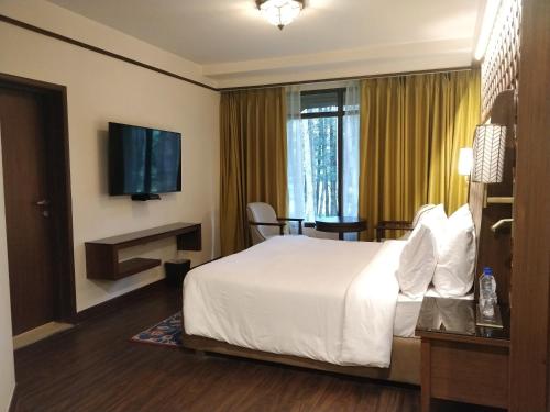 a hotel room with a bed and a television at Radisson Golf Resort Pahalgam in Pahalgām