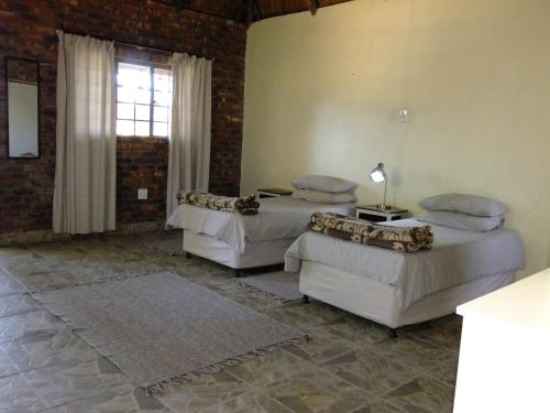 um quarto com três camas e uma janela em Mkolo Hunting and Wildlife 