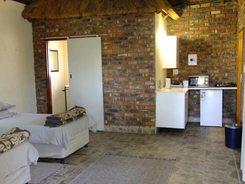 uma cozinha com duas camas e uma parede de tijolos em Mkolo Hunting and Wildlife 