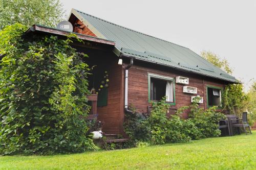 una pequeña casa de madera con techo verde en Słoneczny Klasztorek, en Gardeja