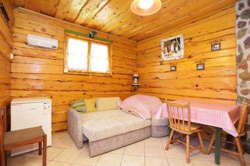 a room with a couch and a table in a log cabin at Apartments for families with children Perusic (Velebit) - 17540 in Perušić