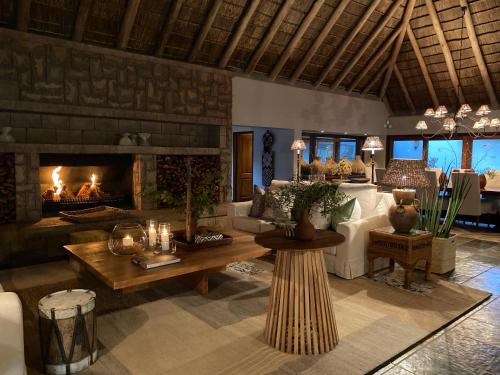 a living room with a fireplace and a couch at Simbavati River Sands in Timbavati Game Reserve