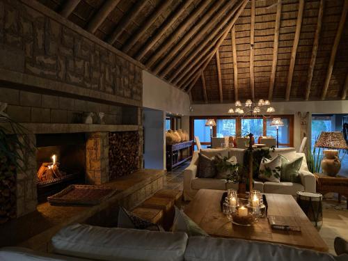 a living room with a couch and a fireplace at Simbavati River Sands in Timbavati Game Reserve