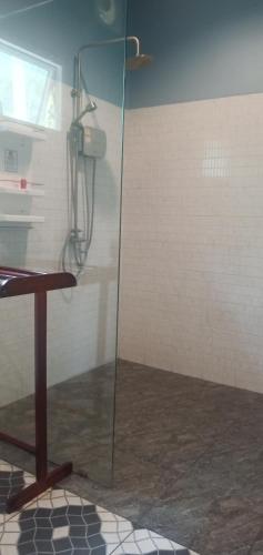 a glass shower in a room with a table at Kohjum Freedom Resort in Ko Jum