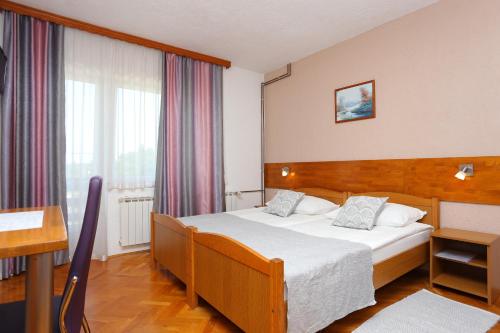 a hotel room with a bed and a desk at Rooms with a parking space Grabovac, Plitvice - 17419 in Rakovica