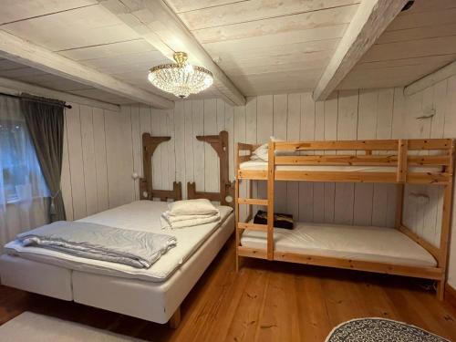 1 dormitorio con 2 literas y lámpara de araña en Dalastuga med tillgång till badplats en Leksand