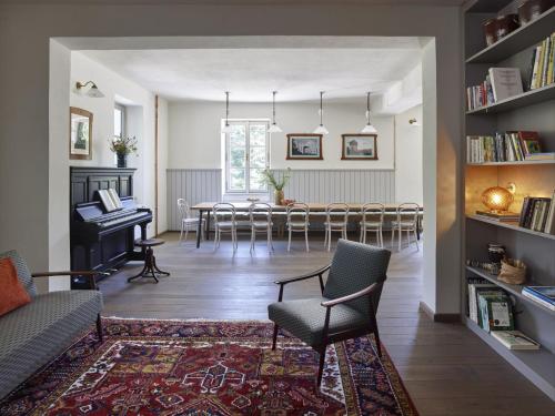 a living room with a piano and a dining room at Tauhaus in Manětín