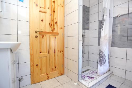 a bathroom with a shower and a wooden door at Apartments for families with children Lipovac, Plitvice - 17556 in Rakovica