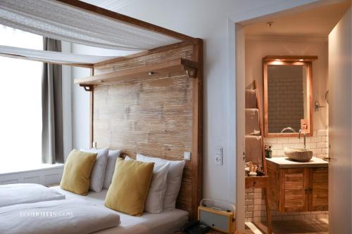 a bedroom with a bed with a wooden headboard at Axel Guldsmeden in Copenhagen