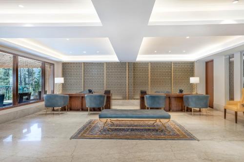 a lobby with a waiting room with a table and chairs at Radisson Golf Resort Pahalgam in Pahalgām