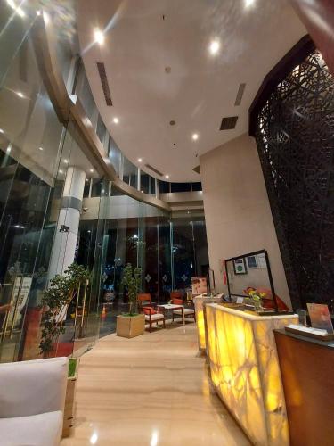 a lobby with chairs and tables in a building at Swiss-Belinn SKA Pekanbaru in Pekanbaru