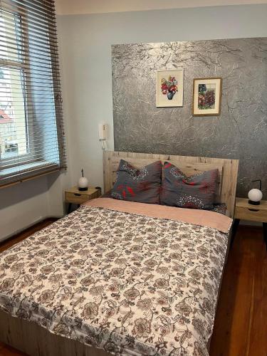 a bedroom with a bed and two pictures on the wall at Jedności Hostel in Zielona Góra