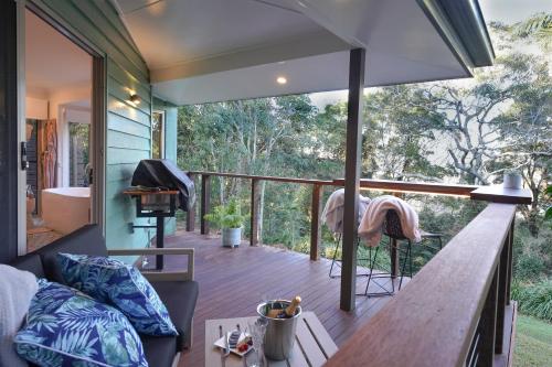 a tiny house with a wrap around deck with a tub at Lovestone Cottages Montville in Montville